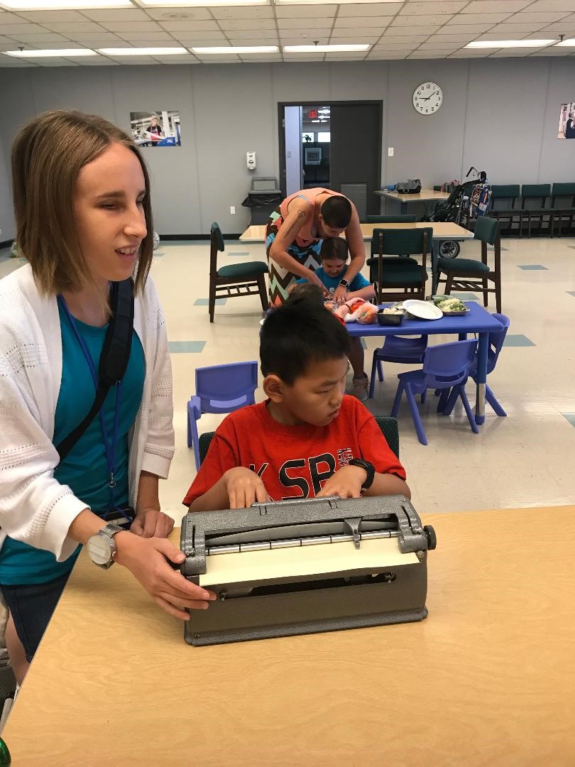 BELL student writes Braille with his teacher